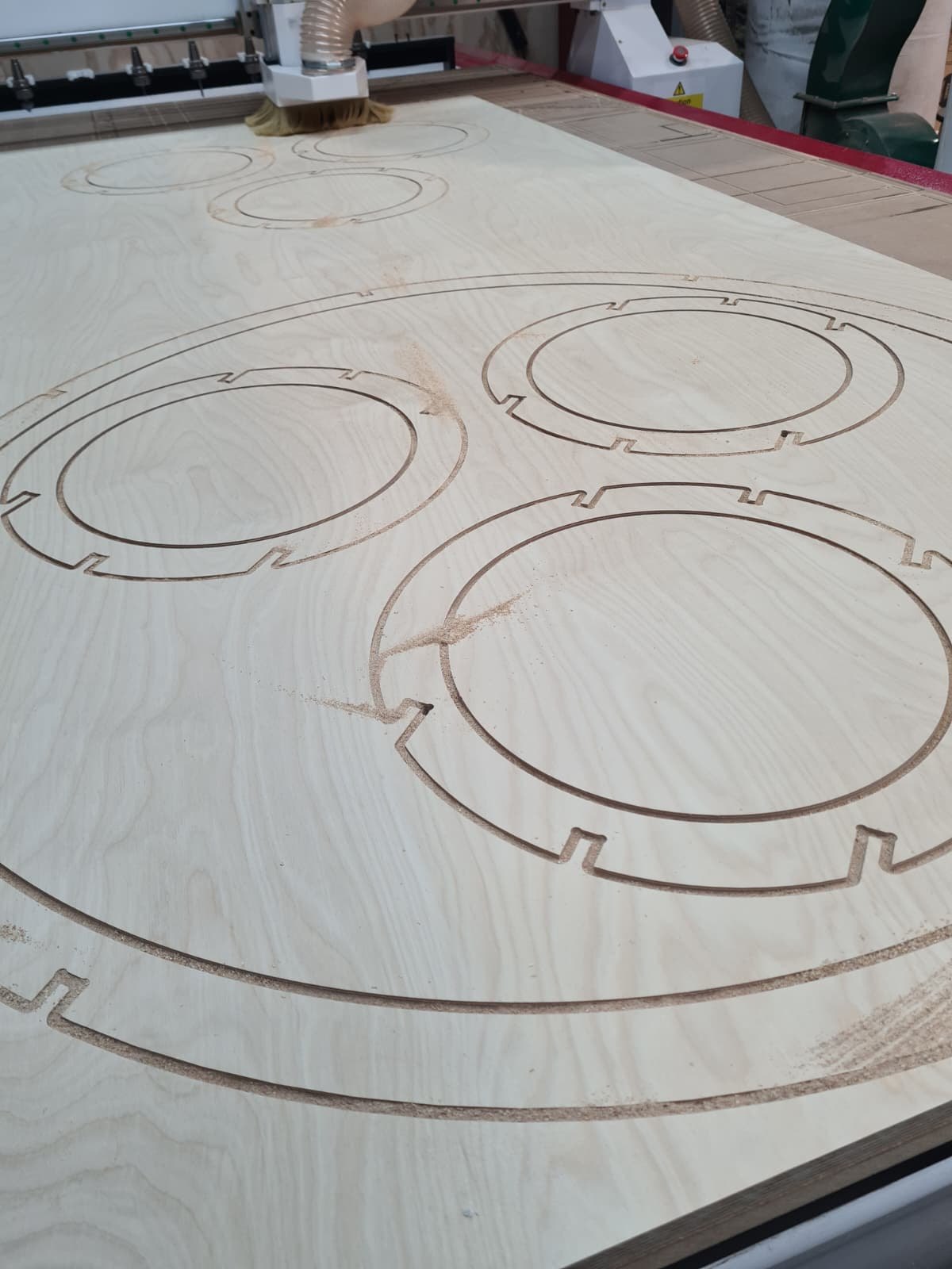 CNC router cutting precise circular parts from a plywood sheet at the Walthamstow workshop
